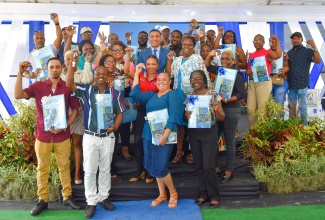 Prime Minister the Most Hon Andrew Holness (centre), is surrounded by new homeowners in the National Housing Trust (NHT) Shrewsbury Housing Development phase two, in Petersfield, Westmoreland, in October.