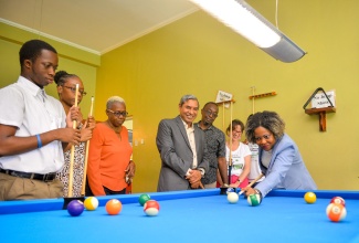 Minister without portfolio in the Office of the Prime Minister with responsibility for Skills and Digital Transformation, Senator Dr. the Hon. Dana Morris Dixon (right), plays a game of pool with student of Caribbean Christian Centre for the Deaf (CCCD), Daquane Williams (left), during Wednesday’s (December 6) launch of FunDoo at the National Commercial Bank (NCB) Wellness and Recreational Centre in Kingston. Sharing in the moment are CCCD educators; UNICEF Jamaica Country Representative, Olga Isaza (second right), and Deputy Representative, Mohammad Mohiuddin (fourth right).