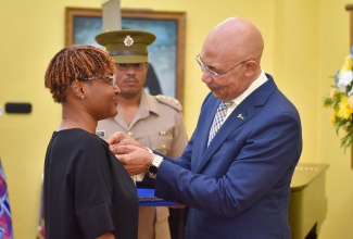 Governor-General, His Excellency the Most Hon. Sir Patrick Allen, places the ‘I Believe’ pin on new Ambassador, Pamela Monroe-Ellis, during Thursday’s (November 30) induction ceremony and reception at Kings House.

