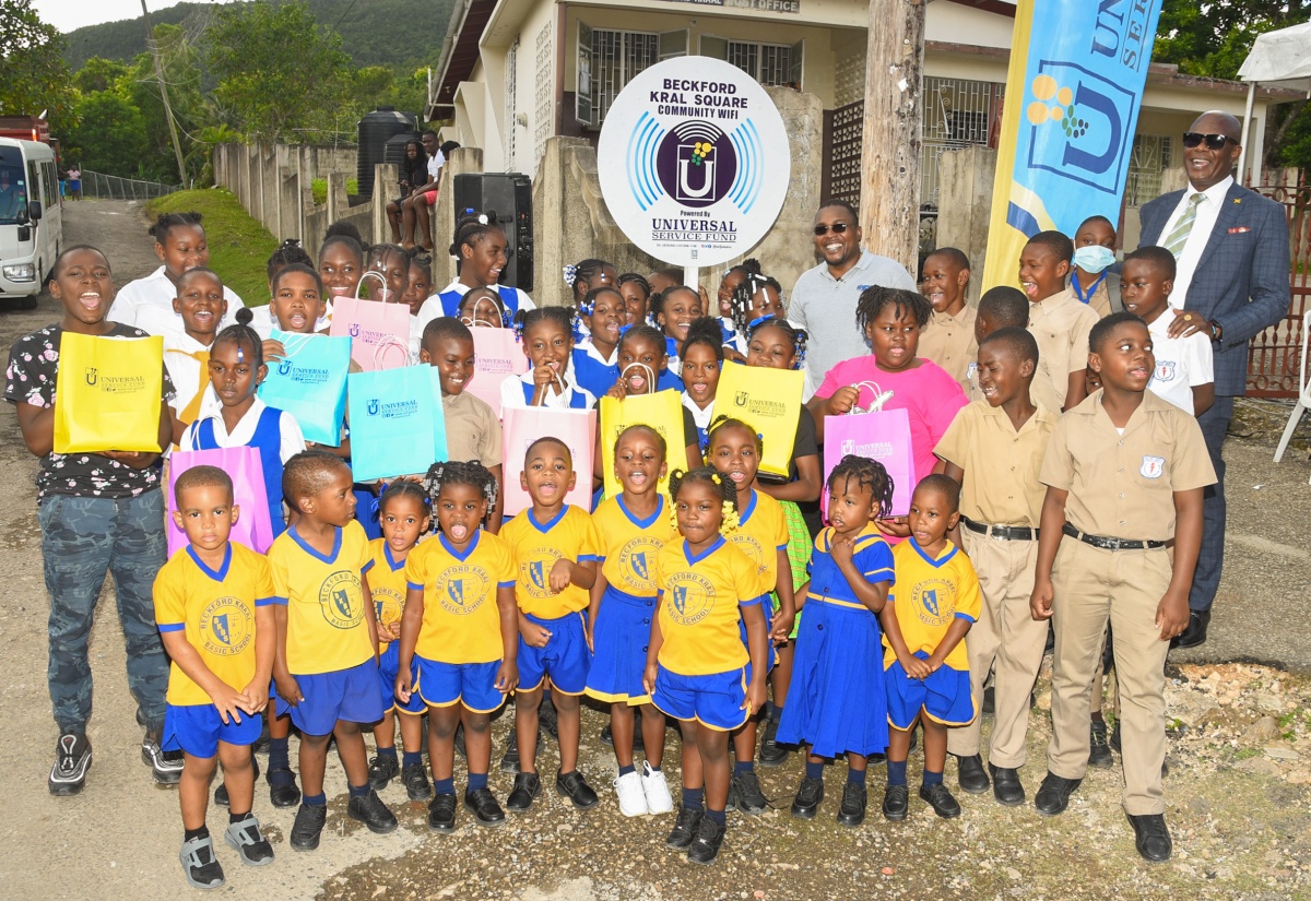Minister with responsibility for Information and Member of Parliament for Clarendon North Central, Hon. Robert Morgan (sixth right, back row); and Chief Executive Officer, Universal Service Fund (USF), Dr. Daniel Dawes (right, back row), are surrounded by students at the launch of USF’s community Wi-Fi programme in Beckford Kraal, Clarendon, on Friday (January 12).