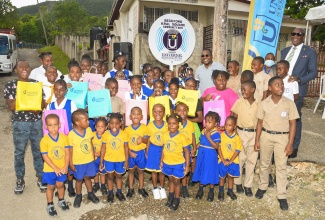 Minister Without Portfolio in the Office of the Prime Minister with responsibility for Information, and Member of Parliament for Clarendon North Central, Hon. Robert Morgan (fifth right, back row); and Chief Executive Officer, Universal Service Fund (USF), Dr. Daniel Dawes (right, back row), interact with students of the Beckford Kraal Basic School during the launch USF’s community wi-fi programme in Beckford Kraal, Clarendon on Friday (January 12).

