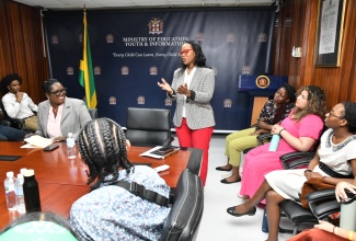 Permanent Secretary in the Ministry of Education and Youth, Dr. Kasan Troupe (standing), addresses members of a delegation from Boston College in Montserrat, who called at the Ministry’s main office in Kingston on Tuesday (January 9).