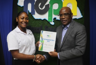 Chief Executive Officer of the National Environment and Planning Agency (NEPA), Peter Knight, presents a certificate of recognition to the winner of the Environmental Hero Competition, Paige Garnett, at NEPA’s offices in Kingston recently.