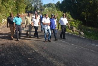 Minister of Agriculture, Fisheries and Mining, Hon. Floyd Green (left, foreground);  Chief Executive Officer (CEO) of the Rural Agricultural Development Authority (RADA), Winston Simpson (second right); and Minister of State in the Ministry of Agriculture, Fisheries and Mining, Hon. Franklin Witter (right), are joined by other representatives from the Ministry, Councillors and other stakeholders in touring a farm road in the Zambia district of Maroon Town, St. James, recently.  The  road is currently under rehabilitation as part of the Government's Farm Road Programme.