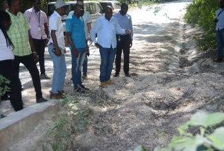 Minister without Portfolio in the Ministry of Economic Growth and Job Creation, Hon. Everald Warmington (second right), is joined by his team from the Ministry, representatives of the National Works Agency (NWA) and other stakeholders as they assess the condition of the road network between Salt Marsh in Trelawny and Adelphi in St. James during a tour on Thursday (January 18).

