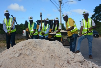 Minister of Economic Growth and Job Creation, Hon. Everald Warmington (third left), breaks ground for the rehabilitation of the Holland to Bounty Hall road in Trelawny on Thursday (Jan.18). He is joined by (from left) Bishop Dalton Collins; Communications and Customer Services Manager of the National Works Agency (NWA), Stephen Shaw; Member of Parliament for Trelawny Northern, Tova Hamilton; Contractor Morris Hill; and NWA’s Regional Manager (West), Robert Francis.