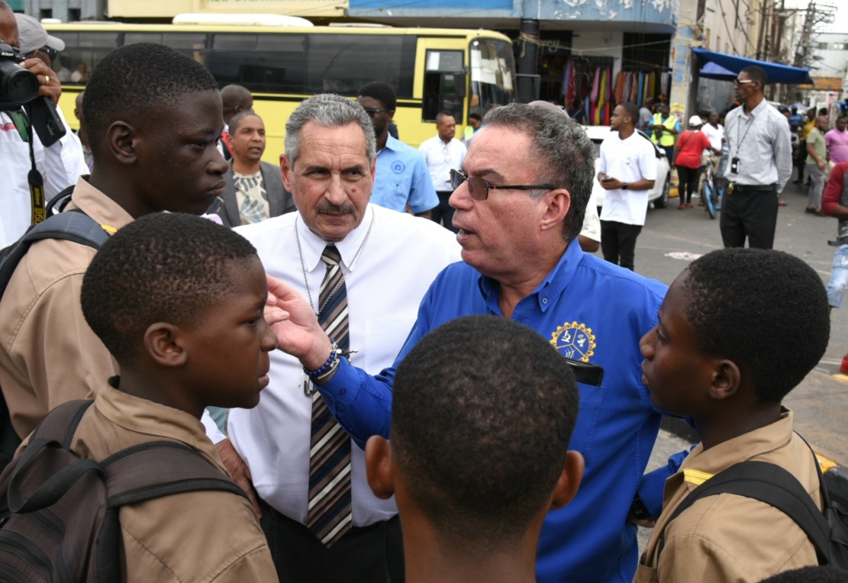Minister of Science, Energy, Telecommunications and Transport, Hon. Daryl Vaz (second right), speaks with several students during a tour and assessment of the bus bays located at North and South Parade in downtown Kingston on Thursday (January 18). With him is Jamaica Urban Transit Company (JUTC) Managing Director, Paul Abrahams.