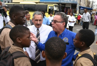 Minister of Science, Energy, Telecommunications and Transport, Hon. Daryl Vaz (second right), speaks with several students during a tour and assessment of the bus bays located at North and South Parade in downtown Kingston on Thursday (January 18). With him is Jamaica Urban Transit Company (JUTC) Managing Director, Paul Abrahams.

