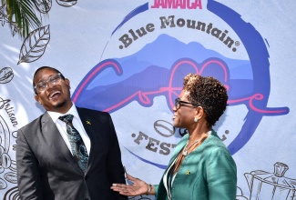 Minister of Agriculture,  Fisheries and Mining, Hon. Floyd Green (left), enjoys a good laugh with Executive Director of Devon House, Georgeia Robinson, during Tuesday’s (January 9) launch of the Blue Mountain Coffee Festival, held at Devon House in Kingston.

