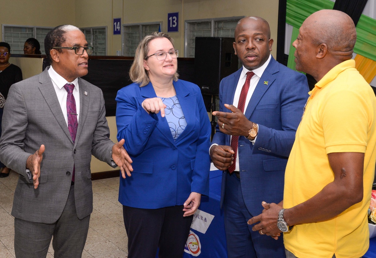Minister of Labour and Social Security, Hon. Pearnel Charles Jr. (second right), along with (from left) State Minister in the Ministry, Dr. the Hon. Norman Dunn and High Commissioner of Canada to Jamaica, Her Excellency Emina Tudakovic, in conversation with experienced farm worker of over 30 years, Noel Johnson (right), at the send-off of 111 participants in the Seasonal Agricultural Workers Programme (SAWP), during a ceremony held at the Overseas Employment Centre, East Street, Kingston, today (January 3).