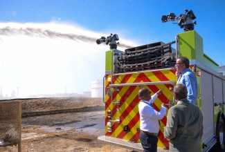 Minister of Science, Energy, Telecommunications and Transport, Hon. Daryl Vaz (on fire truck); Member of Parliament for Kingston Western, Hon. Desmond McKenzie (right), and General Manager of Petrojam, Telroy Morgan, at the commissioning of the Foam Fire Truck, today (January 23), at the refinery’s headquarters on Marcus Garvey Drive in Kingston. An ambulance was also handed over to the entity.

