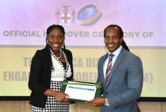 Minister of State in the Ministry of Foreign Affairs and Foreign Trade, Hon. Alando Terrelonge, along with Project Manager with the International Organization for Migration (IOM), Krystal Loffters, display the certificate for the Jamaica Diaspora Engagement Model (JAM-DEM) portal, at a handover ceremony held at the Ministry’s offices, downtown Kingston, today (January 30).

