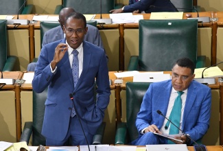 Minister of Finance and the Public Service, Dr. the Hon. Nigel Clarke, speaks in the House of Representatives, on Tuesday (January 23). Listening at right is Prime Minister, the Most. Hon. Andrew Holness.