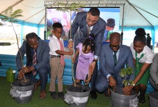 Prime Minister, the Most Hon. Andrew Holness, gets assistance from Jordan Josephs (second left) of Portsmouth Primary School and Yelizaveta Thompson (centre) of Sabina Infant, in planting a tree during the official launch of the Portmore Resilience Park in St. Catherine on Wednesday (January 17). They are joined by (from left) Minister of State in the Ministry of Foreign Affairs and Foreign Trade and Member of Parliament, St. Catherine East Central, Hon. Alando Terrelonge; Member of Parliament for St. Catherine South Eastern, Robert Miller; and student, Old Harbour High School, Abbygayle Palmer. Construction for the park is expected to begin in February and is slated for completion in September 2025.