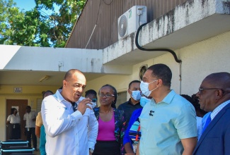 Prime Minister, the Most Hon. Andrew Holness (second from right), is briefed by Minister of Health and Wellness, Dr. the Hon. Christopher Tufton (left, foreground), on plans for the Type V Montego Bay Comprehensive Health Centre in St. James, during a tour of the facility on Monday (January 8). Looking on is St James Health Services Parish Manager, Lennox Wallace (right) and Minister of Local Government and Community Development, Hon. Desmond McKenzie (left).