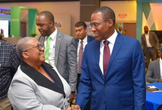 Minister of Finance and the Public Service, Dr. the Hon. Nigel Clarke (right), is greeted by Managing Director, Jamaica Stock Exchange Group, Dr. Marlene Street Forrest, during today’s (January 24) session of the Jamaica Stock Exchange (JSE) Investments and Capital Market Conference at The Jamaica Pegasus hotel in New Kingston.