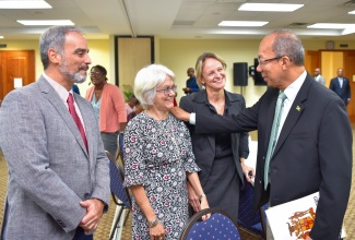Deputy Prime Minister and Minister of National Security, Hon. Dr. Horace Chang (right), greets Chairman of the Violence Prevention Alliance (VPA), Professor Elizabeth Ward (second right) during the closing-out ceremony for the review of the technical assistance to the Citizen Security Plan (CSP), at the University of the West Indies Regional Headquarters on January 25. Sharing in the moment (from left) are International Aid/Programme Manager Cooperation Section, Delegation of the European Union to Jamaica, Luca Lo Conte and Violence Prevention and Citizen Security Expert, Heather Sutton.