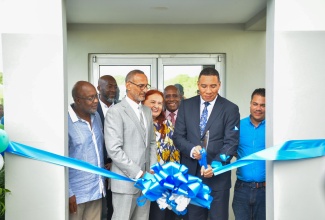 Prime Minister the Most Hon. Andrew Holness (second right) cuts the ribbon symbolising the official opening of a new recycling plant of Recycling Partners of Jamaica (RPJ) at Naggo Head, Portmore, St. Catherine, recently. He is joined by (from left) Member of Parliament, St. Catherine Southern, Fitz Jackson; Managing Director, Recycling Partners of Jamaica, Gairy Taylor; Executive Chairman, Recycling Partners of Jamaica, Dr. Damien King; board member, RPJ, Emma Lewis; Minister of Industry, Investment and Commerce, Senator the Hon. Aubyn Hill and Minister without Portfolio in the Ministry of Economic Growth and Job Creation, Senator the Hon. Matthew Samuda.

