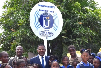 Chief Executive Officer of the Universal Service Fund (USF), Dr. Daniel Dawes (fourth left), and Kingston Eastern and Port Royal Member of Parliament, Phillip Paulwell, are surrounded by students from Holy Rosary Primary School, at the launch of community Wi-Fi at Windward Courts (Bower Bank), Kingston, on January 15.