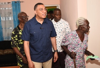 Prime Minister, the Most Hon. Andrew Holness (front left); Minister of Local Government and Community Development, Hon. Desmond McKenzie (background left) and Councillor for the Riverside Division, Darren Barnes (background right), examine the new two-bedroom home handed over to Indigent Housing Programme beneficiary, Kathrine Miller (front right) in Chambers Pen, Hanover, on January 20.

