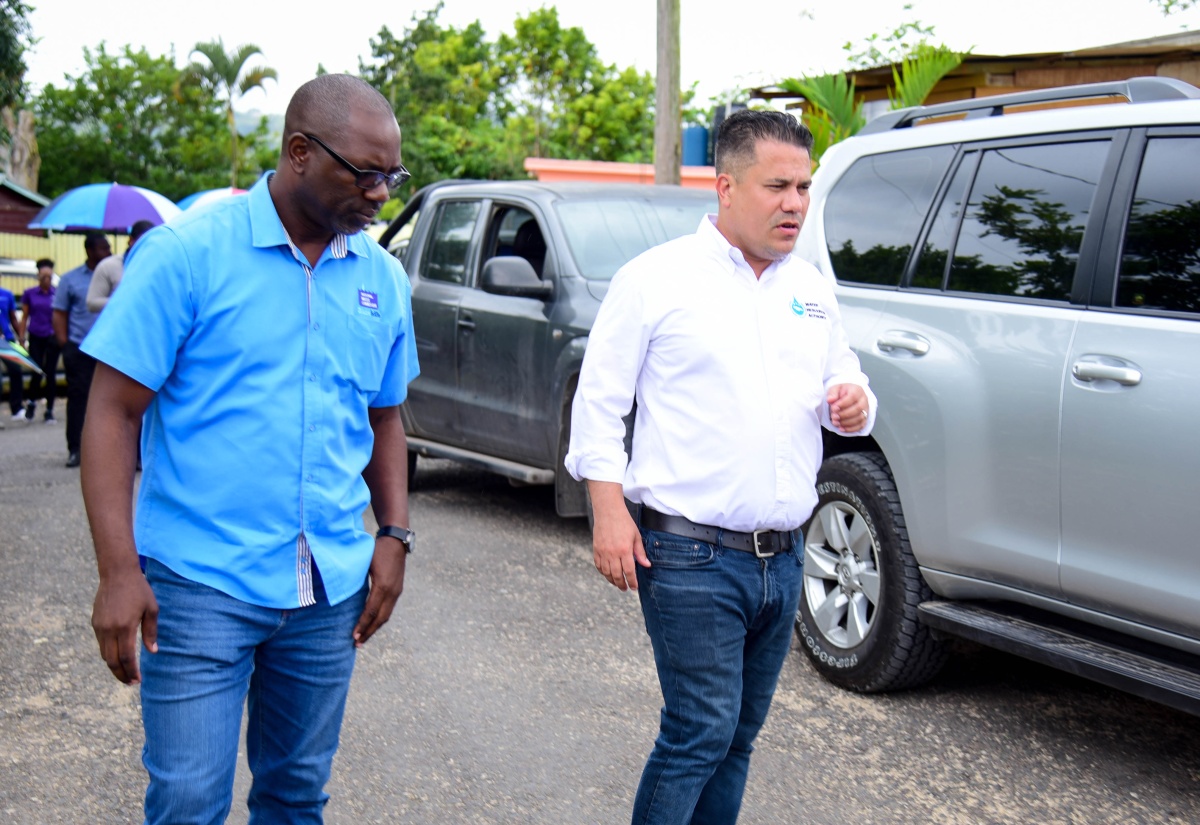 Minister Without Portfolio in the Ministry of Economic Growth and Job Creation, Senator the Hon. Matthew Samuda (right), converses with National Water Commission (NWC) Corporate Public Relations Manager, Delano Williams, during a tour of the water systems in Clarendon North Western on Tuesday (February 20).