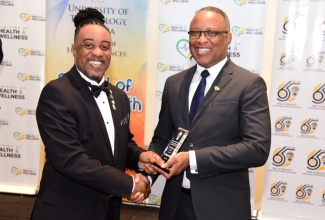 Permanent Secretary in the Ministry of Health and Wellness, Dunstan Bryan (right), presents the Outstanding Performer Award to Chief Executive Officer, St. Joseph’s Hospital, Dr. Christopher Munroe, during a recent graduation ceremony for 39 public health personnel who participated in a Healthcare Administration and Leadership certification course at the University of Technology (UTech). The ceremony was held at The Jamaica Pegasus hotel in New Kingston.

