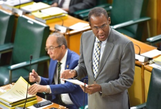 Minister of Finance and the Public Service, Dr. the Hon. Nigel Clarke, tables the 2024/25 Estimates of Expenditure in the House of Representatives on Thursday (February 15). At left is Deputy Prime Minister and Minister of National Security, Hon. Dr. Horace Chang.