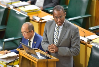 Minister of Finance and the Public Service, Dr. the Hon. Nigel Clarke, tables the 2024/25 Estimates of Expenditure in the House of Representatives on Thursday (February 15). At left is Deputy Prime Minister and Minister of National Security, Hon. Dr. Horace Chang.