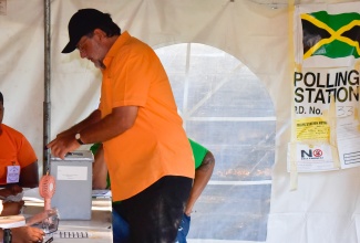 Leader of the Opposition, Mark Golding, shows his inked right index finger as he casts his ballot in the 2024 Local Government Elections at the polling station located on Dillsbury Avenue, Jack