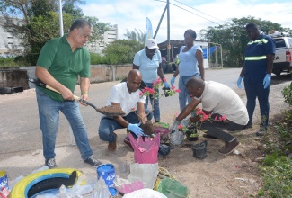 WPM Waste Management Limited team members participate in the repurposing of disposable material into flower pots during Tuesday’s (February 13) ‘For the Love of the Environment Cleanup and Beautification Initiative’ in Cooper's Pen, Trelawny, which was spearheaded by the entity. From left are: Fleet Manager, Lloyd Young; Regional Operations Manager, Edward Muir; Sweepers, Fayann Brown and Tanika Haye; Enforcement Officer, Allistair Black; and Sweeper, Ingrid Barrett