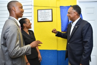 Minister of State in the Ministry of Education and Youth, Hon. Marsha Smith (centre), along with (from left) Principal, Grange Hill Primary School, Clayton E. Smith, and Managing Director, Jamaica Social Investment Fund (JSIF), Omar Sweeney, view a plaque unveiled following the official opening of a classroom block at the institution in November 2023.

