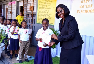 Principal of the St. Andrew based Half-Way Tree Primary School, Carol O’Connor Clarke,  presents a certificate to student  Jala keyes for perfect attendance over the past 100 days. She was one of  91 students recognised for the feat. The event was held at the school, today (February 12).

