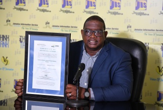 Director General, Hazardous Substances Regulatory Authority (HSRA), Dr. Cliff Riley, displays a copy of the certification of authorisation provided to facilities that use ionising radiation sources in their operations, while speaking during a recent Jamaica Information Service (JIS) ‘Think Tank’ at the Agency’s head office in Kingston.