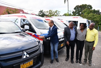 Chairman of the Southern Regional Health Authority (SRHA), Wayne Chen (left), cuts the ribbon during the ceremony for the official handover of nine new vehicles, at the SRHA office in Mandeville on Friday (February 2). Looking on (from second left) are Regional Director, Michael Bent; Director of Facilities, Operations and Maintenance, Herschel Ismail; and Manager of the Transport Department, Robert Robinson.

