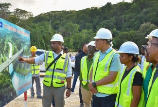 Prime Minister, the Most Hon. Andrew Holness (third left), looks on as Managing Director of the National Road Operating and Constructing Company Limited (NROCC), Stephen Edwards (left), outlines the scope of works on the Montego Bay Perimeter Road in St. James during a tour of the project on January 8. The Prime Minister was accompanied by Minister of Local Government and Community Development, Hon. Desmond McKenzie (second left); Minister of Legal and Constitutional Affairs, Hon. Marlene Malahoo Forte (third right); and Deputy Prime Minister and Minister of National Security, Hon. Dr. Horace Chang (right).