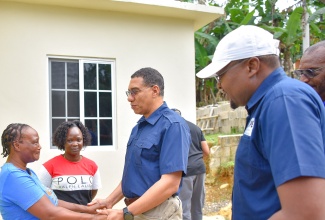 Prime Minister, the Most Hon. Andrew Holness (second right), engages with New Social Housing Programme (NSHP) beneficiary, Evadne Carty (left), during the handover of a new two-bedroom unit in Beckford Kraal, Clarendon, on Friday (February 2). Sharing the moment are Ms. Carty’s daughter Shanna-Kay Beckford and Member of Parliament for Clarendon North Central, Hon. Robert Morgan.

