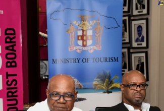 Minister of Tourism, Hon. Edmund Bartlett, addresses the Global Tourism Resilience Conference press briefing at the Jamaica Tourist Board in New Kingston on Tuesday (February 13).  Listening is Executive Director of the Global Tourism Resilience and Crisis Management Centre at the University of the West Indies, Professor Lloyd Waller.