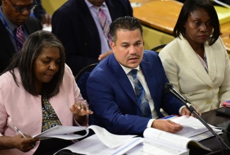 Minister without Portfolio in the Ministry of Economic Growth and Job Creation, Senator the Hon. Matthew Samuda (centre), responds to questions posed during today’s (March 6) sitting of the Standing Finance Committee of the House of Representatives. With the Minister are (from left) Chairperson for the Oversight Committee of the New Social Housing Programme, Judith Robb Walters and Permanent Secretary in the Ministry, Arlene Williams.

