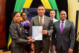 Prime Minister, the Most Hon. Andrew Holness (centre), hands over a birth certificate to Tavia Richards-Murray, guardian for Ashley Williams, one of the first recipients under the National Identification System (NIDS) ‘Operation Birthright’ Programme, that was launched at Jamaica House in Kingston on September 9, 2022. Sharing the moment are then Minister without Portfolio in the Office of the Prime Minister, Hon. Floyd Green (right); Modernisation of State Specialist, Inter-American Development Bank, Benjamin Roseth, and Representative of the Leader of the Opposition, Dr. Angela Brown-Burke.

