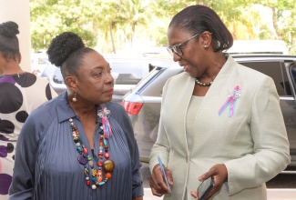 Minister of Culture, Gender, Entertainment, and Sport, Hon. Olivia Grange (left), listens to a point from Acting Senior Director of the Bureau of Gender Affairs, Sharon Coburn Robinson, during a recent International Women's Day (IWD) event at The Jamaica Pegasus hotel in New Kingston.

