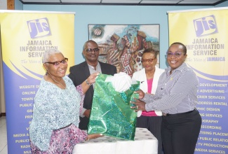 Chief Executive Officer at the Jamaica Information Service (JIS), Enthrose Campbell (second right) and Finance Manager, Glenford West (second left) look on as Company Secretary and Director of Action Chemicals and Equipment, Marva Bernard (left), hands over a package containing sanitation supplies to Board Chairman and Interim Director of Mount Olivet Boys’ Home, Sophia Morgan (right). The presentation was made at the JIS’s offices in Kingston on March 1. The items were provided by Action Chemicals and Equipment, and IJASS Trading Limited, through an initiative of the JIS Finance Department.

