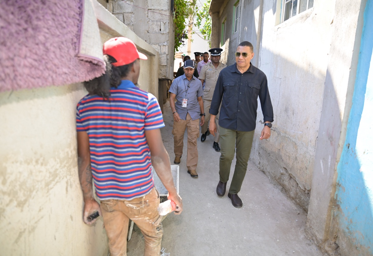 Prime Minister, the Most Hon. Andrew Holness conducts a tour of the community of Morgans Place in Olympic Way on Thursday (March 28), where improvement work is now underway under the Urban Renewal and Development Programme.