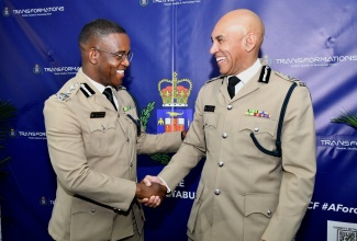 New Commissioner of Police, Dr. Kevin Blake (left), receives a congratulatory handshake from Outgoing Commissioner, Major General Antony Anderson, during the Change of Command ceremony held at the Office of the Police Commissioner, located at 101-105 Old Hope Road in St. Andrew on March 18.