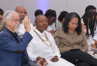 Minister of Culture, Gender, Entertainment and Sport, Hon. Olivia Grange (centre), joins in prayer with Chief Vision Officer of Glory Music, Tommy Cowan (left) and Festival Director for Fun in the Son, Danah Cameron, at the launch of the event held at the AC Hotel by Marriott in Kingston on Tuesday (March 5).