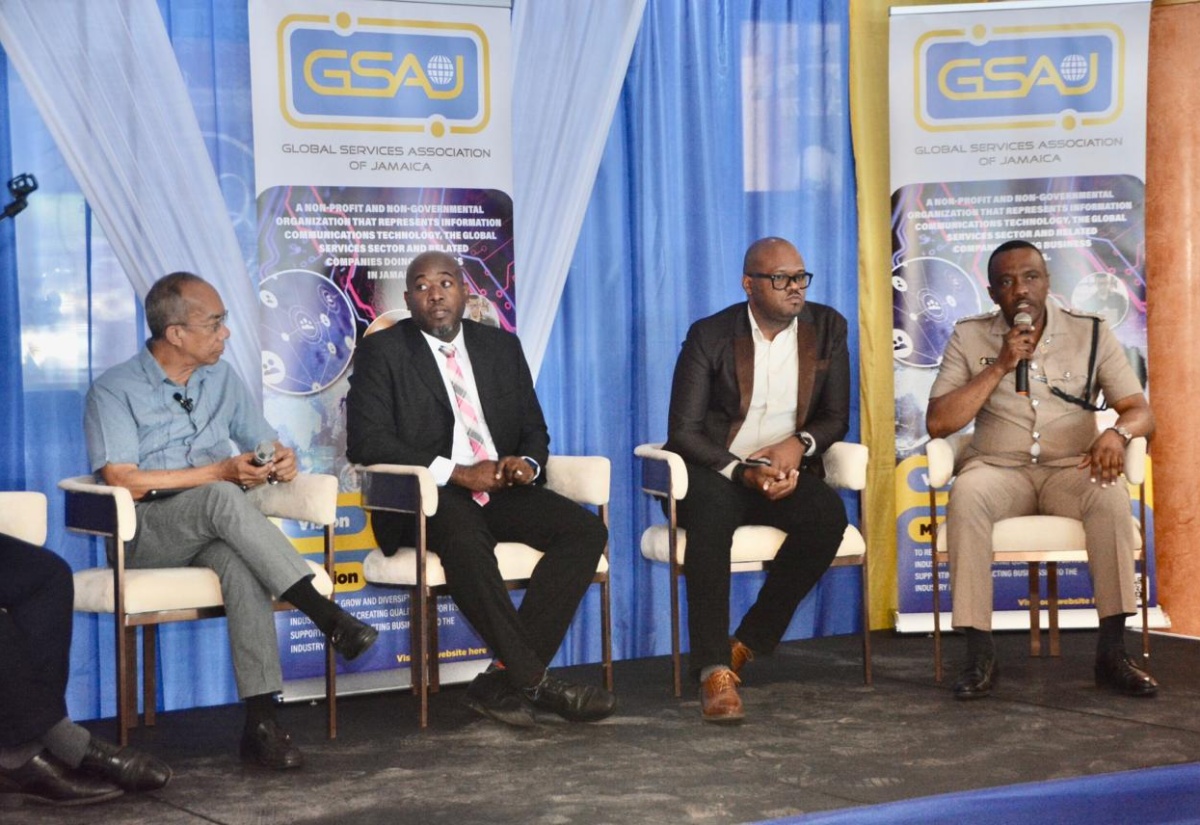 Deputy Prime Minister and Minister of National Security, Hon. Dr. Horace Chang (left), listens to remarks by Acting Assistant Commissioner of Police in charge of Jamaica Constabulary Force (JCF) Area One, Vernon Ellis (right), during a panel discussion forming part of the recent Global Services Association of Jamaica (GSAJ) President’s Breakfast Forum at the Grand-A-View Event Place in Montego Bay, St. James. Others participating are Information Systems Manager, Office of the Information Commissioner, Ronald Frue (second left); and Communications Officer for the JCF’s Communication Forensics and Cybercrime Division (CFCD), Deputy Superintendent of Police Maurice Goode.