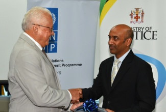 Minister of Justice, Hon Delroy Chuck (left), is presented with a stenography machine by Resident Representative, United Nations Development Programme (UNDP), Kishan Khoday. Occasion was the recent handover of stenography devices and laptops valued at more than $30 million by the Government of Canada through the Social Justice Project (SO-JUST) to the Court Administration Division and the Justice Training Institute, at the University of the West Indies (UWI) Regional Headquarters in Mona, St. Andrew.