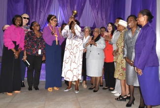 Minister of Culture, Gender, Entertainment and Sport, Hon. Olivia Grange (centre) rings the bell for gender equality, at the Jamaica Stock Exchange (JSE), International Women