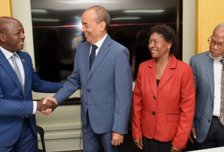 Minister of Labour and Social Security, Hon. Pearnel Charles Jr. (left), shakes hands with President of the Jamaica Employers’ Federation (JEF), Wayne Chen (second left), during a courtesy call at the Ministry in Kingston on Wednesday (March 20). Accompanying Mr. Chen are JEF Vice President, Bernita Locke, and Secretary, Silvera Castro.