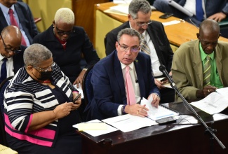 Minister of Science, Energy, Telecommunications and Transport, Hon. Daryl Vaz (centre), addresses the Standing Finance Committee in the House of Representatives on March 5. The Minister is flanked by Permanent Secretary in the Ministry, Carol Palmer (left) and State Minister, Hon. J.C. Hutchinson (right). 