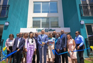 Prime Minister, the Most Hon. Andrew Holness (third left), cuts the ribbon during a ceremony at The Vineyards at Deanery apartment complex in Vineyard Town, Kingston, on Wednesday (March 27). Other participants include (from left, front row) Director, Comfort Apts. Development Limited, Linval Freeman; Board Director, Jamaica Mortgage Bank (JMB), Kari Douglas; Member of Parliament, St. Andrew South Eastern, Julian Robinson, as well as JMB and Vineyards of Deanery Board of Directors.


